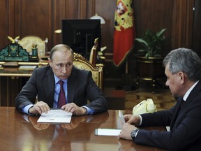 Russian President Vladimir Putin talks with Defence Minister Sergei Shoigu at the Kremlin in Moscow, Russia, March 14, 2016. (REUTERS/Mikhail Klimentyev/Sputnik/Kremlin)