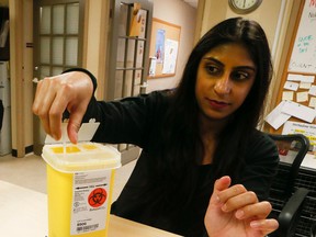 Health promotion specialist Samira Walji demonstrates the safe disposal of needles after drug injection as Toronto health officials release their report calling for the introduction of safe-injection sites in Toronto Monday, March 14, 2016. (Stan Behal/Toronto Sun)