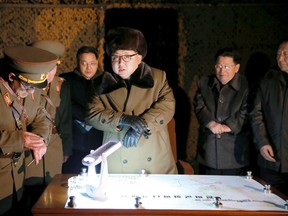 North Korean leader Kim Jong Un talks with officials at the ballistic rocket launch drill of the Strategic Force of the Korean People's Army (KPA) at an unknown location, in this undated photo released by North Korea's Korean Central News Agency (KCNA) in Pyongyang on March 11, 2016. (REUTERS/KCNA)
