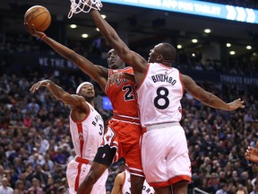 Bulls forward Tony Snell (20) attempts a shot as Raptors centre Bismack Biyombo (right) and Terrence Ross (left) defend during NBA action in Toronto on Monday, March 14, 2016. (Tom Szczerbowski/USA TODAY Sports)