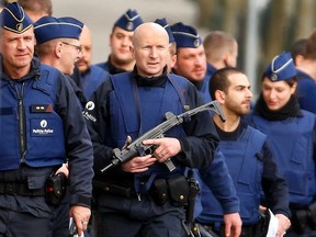 Police at the scene where shots were fired during a police search of a house in the suburb of Forest near Brussels, Belgium, March 15, 2016. (REUTERS/Yves Herman)