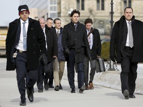 Canada's Prime Minister Justin Trudeau (C) is surrounded by security and staff while walking from Parliament Hill to a news conference in Ottawa on February 8, 2016. REUTERS/Chris Wattie