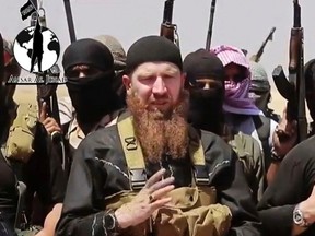 Omar al-Shishani standing next to the group's spokesman among a group of fighters as they declare the elimination of the border between Iraq and Syria. (AP Photo/militant social media account via AP video)