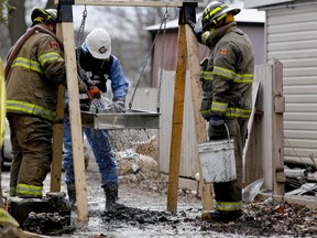 Emily Mountney-Lessard/Intelligencer file photo
An investigator with the Ontario Fire Marshall office, with help from members of the Prince Edward County Fire Department, sifts through debris at the scene of a house fire on Sunday. The fire took place Saturday morning and killed a 25-year-old man.