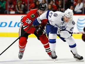 Chicago Blackhawks winger Ryan Garbutt (28) and Tampa Bay Lightning winger Jonathan Drouin (27) battle during a game in Chicago, Saturday, Oct. 24, 2015. (AP Photo/Andrew A. Nelles)