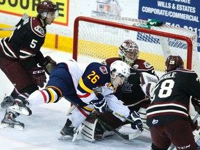 Peterborough Petes' defenceman Dominic Masin (5) trips Barrie Colts' Andrew Mangiapane into goalie Matt Mancina during second period OHL action on Tuesday March 15, 2016 at the Memorial Centre in Peterborough, Ont. (Clifford Skarstedt, Postmedia Network)