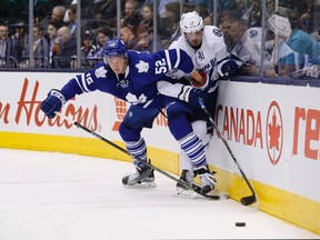 Martin Marincin of the Toronto Maple Leafs (left) battles for the puck with Tampa Bay Lighting's Alex Killorn during the first period of NHL action in Toronto on March 15, 2016. (MARK BLINCH/The Canadian Press)
