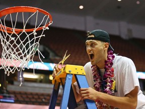 Hawaii forward Stefan Jankovic helps to cut down the nets following Hawaii’s Big West Conference tournament championship on March 12, 2016. (LENNY IGNELZI/The Associated Press)