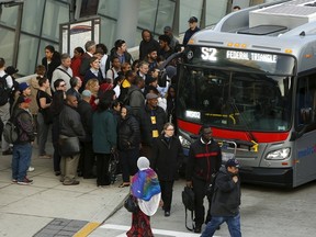 A long line of morning commuters board a bus for downtown Washington in Silver Spring, Maryland March 16, 2016. (REUTERS/Gary Cameron)