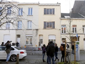 Reporters stand in front of an apartment, centre, in the Brussels district of Forest where a gunman was shot dead by Belgian police on Tuesday after a raid on the apartment linked to investigations into November's Islamist attacks in Paris March 16, 2016. (REUTERS/Francois Lenoir)
