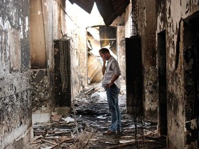 In this Oct. 16, 2015, file photo, an employee of Doctors Without Borders walks inside the charred remains of the organization's hospital after it was hit by a U.S. airstrike in Kunduz, Afghanistan. More than a dozen U.S. military personnel have been disciplined but face no criminal charges for mistakes that led to the bombing of a Doctors Without Borders hospital in Afghanistan last year that killed 42 Afghans, U.S. defense officials say. (AP Photo/Najim Rahim, File)