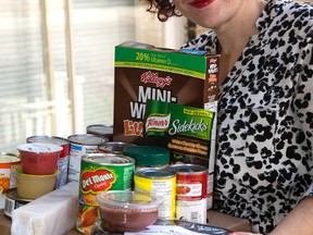 Sarah Campbell, the executive director of Meals On Wheels, shows some of the contents of a box of London Food Bank staples that will be delivered on a monthly basis to about 200 clients. (MIKE HENSEN, The London Free Press)