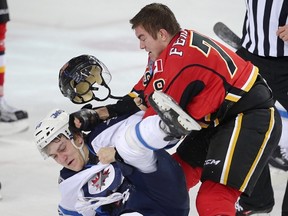 JC Lipon of the Winnipeg Jets fights Michael Ferland of the Calgary Flames during NHL hockey in Calgary, Alta., on Wednesday, March 16, 2016. AL CHAREST/POSTMEDIA