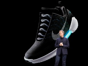 An image of the Nike HyperAdapt 1.0 is projected on a screen as Nike CEO Mark Parker speaks during a news conference, Wednesday, March 16, 2016, in New York. (AP Photo/Mary Altaffer)