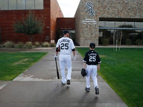 In this Feb. 28, 2015, file photo, Chicago White Sox first baseman Adam LaRoche, left, and his son Drake walk to the team’s clubhouse during spring training in Phoenix. (AP Photo/John Locher, File)