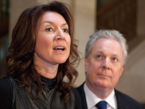 Deputy premier Nathalie Normandeau announces her resignation as Quebec Premier Jean Charest looks on at a news conference Tuesday, September 6, 2011 at the legislature in Quebec City. Several media reports say Normandeau has been arrested by the province's anti-corruption unit.THE CANADIAN PRESS/Jacques Boissinot