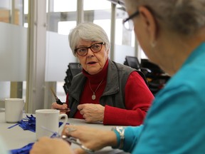 Jason Miller/The Intelligencer
Donna Creeggan speaks to Mary Hull while they sip tea and make blue ribbons inside the seniors centre at the Quinte Sport and Wellness Centre.