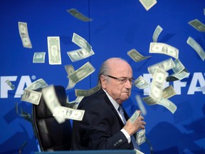 In this July 20, 2015 file photo, FIFA president Sepp Blatter is photographed while banknotes thrown by British comedian Simon Brodkin fly through the air during a press conference following the extraordinary FIFA Executive Committee in Zurich, Switzerland. Former president Blatter's secret pay deal was revealed to be $3.76 million in 2015. (Ennio Leanza/Keystone via AP/Files)