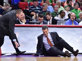 Virginia Cavaliers head coach Tony Bennett collapses on the floor as assistant athletic director Ronnie Wideman reacts during the first half Thursday against the Hampton Pirates at PNC Arena. (Bob Donnan/USA TODAY Sports)