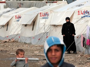 A Syrian refugee stands outside the family tent at a refugee camp for Syrian refugees in Islahiye, Gaziantep province, southeastern Turkey,Wednesday, March 16, 2016. (AP Photo/Lefteris Pitarakis)