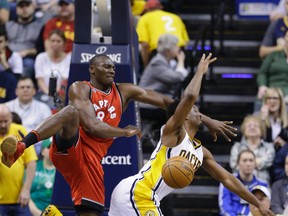Raptors centre Bismack Biyombo (left) fouls Pacers forward Solomon Hill (right) during first half NBA action in Indianapolis on Thursday, March 17, 2016. (Michael Conroy/AP Photo)