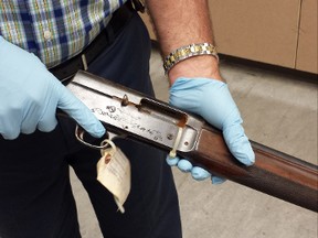 In this June 2015 photo released by the Seattle Police on Thursday, March 17, 2016, Detective Michael Ciesynski holds the shotgun which rock legend Kurt Cobain used to kill himself on April 8, 1994. Police did not say why they took the photos last year or why they're releasing them to the public at this time. (Seattle Police via AP)