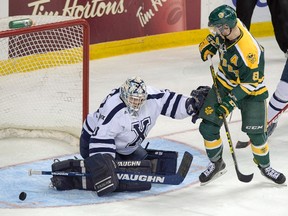 The U of A Golden Bears outshot rival St. Francis Xavier 45-27 but came up short in their tournament opener Thursday in Halifax. X-Men goalie Drew Owsley, shown here stopping Bears forward Brett Ferguson, made 43 saves in the game. (The Canadian Press)