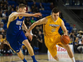 Ryerson University Rams #4 Ammanuel Diressa ( R ) drives around UBC Thunderbirds #9 Conor Morgan ( L )  in a session 1 basketball game at the CIS Men's Basketball Final 8 National Championships at UBC, Vancouver March 17 2016.  (Gerry Kahrmann  / Postmedia Network )