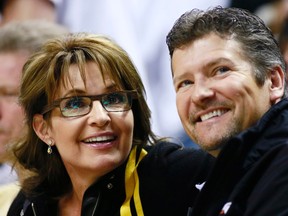 Former U.S. Republican vice-presidential candidate Sarah Palin and her husband Todd take in Game 3 of the NBA Eastern Conference final basketball playoff series between the Miami Heat and the Indiana Pacers in Indianapolis, Indiana, in this May 26, 2013, file photo. Former U.S. vice presidential nominee Sarah Palin said on March 17, 2016, that her husband Todd, who was seriously injured in a snowmobile accident, was still in a hospital intensive care unit after surgery.  REUTERS/Brent Smith/Files
