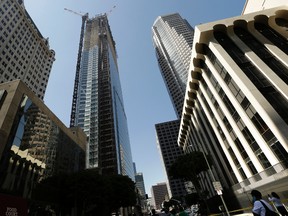 Passerby's look up at the Wilshire Grand Tower on South Figueroa Street where a worker fell to his death on Thursday, March 17, 2016. (AP Photo/Nick Ut)