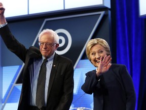 In this March 9, 2016, photo, Democratic U.S. presidential candidates, Hillary Clinton and Sen. Bernie Sanders stand together before the start of the Univision, Washington Post Democratic presidential debate at Miami-Dade College in Miami. (AP Photo/Wilfredo Lee)