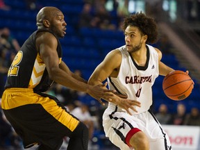 Carleton Ravens’ Kaza Kajami-Keane (right) wheels around Kashrell Lawrence of the Dalhousie Tigers in their CIS men's basketball semifinal. 
(Gerry Kahrmann/Postmedia Network)