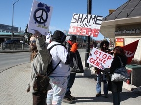 Members of the Canadian Peace Congress stage a demonstration and information picket at the corner of Elm Street and Notre Dame Avenue in Sudbury on Saturday as part of a cross-Canada day of action to call on the Liberal government to end all military involvement in the region. Ben Leeson/The Sudbury Star/Postmedia Network