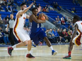 Ryerson Rams' Roshane Roberts, second from left, carries the ball past Calgary Dinos' Jasdeep Gill, left, and Jhony Verrone during semifinal CIS men's national university basketball championship action in Vancouver on Saturday, March 19, 2016. (THE CANADIAN PRESS/Darryl Dyck)