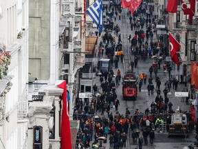 People walk on Istiklal Street near the sit of  Saturday's bomb explosion, in Istanbul, Sunday, March 20, 2016. A suicide attack on Istanbul's main pedestrian shopping street Saturday killed five people, including two dual nationality Israeli-Americans and one Iranian citizen, and wounded several dozen others, in the sixth suicide bombing in Turkey in the past year. Turkey's Interior Minister Efkan Ala has identified the Istanbul suicide bomber as a militant with links to the Islamic State group. Ala told reporters Sunday that the bomber has been identified as Turkish citizen Mehmet Ozturk, who was born in 1992 in Gaziantep province, which borders Syria. (AP Photo/Emrah Gurel)