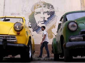 A man walks past a painting of the late revolutionary hero Ernesto "Che" Guevara in Havana, Cuba March 19, 2016. REUTERS/Ueslei Marcelino