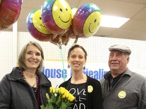 Leslie Pevec, left, Teresa Guerette, and Steve Raes were trying to spread happiness in Sarnia Sunday, as part of the International Day of Happiness. The trio had a booth set up at the downtown flea market and were handing out flowers and smiles to passersby. (Tyler Kula, The Observer)