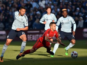 Sporting KC player Roger Espinoza (27) trips up Toronto FC player Sebastian Giovinco (10) during the first half at Children's Mercy Park on Sunday. (USA TODAY Sports)