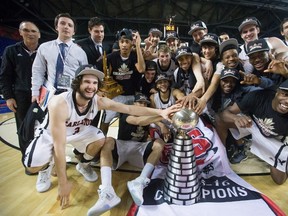 The Carleton Ravens pose with the W. P. McGee Trophy as they celebrate after defeating the University of Calgary Dinos to win the CIS men's national university basketball championship final in Vancouver, B.C., on Sunday March 20, 2016. THE CANADIAN PRESS/Darryl Dyck