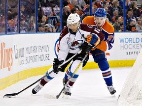 Jarome Iginla is chased behind the net by Connor McDavid. (The Canadian Press)