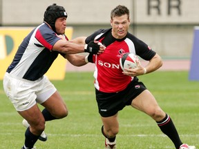 Canada's John Cannon (right) holds off USA's Salesi Sika during the second half of play in the bronze-medal game at the Churchill Cup rugby tournament at Commonwealth Stadium in Edmonton, Alta., on Sunday June 26, 2005.