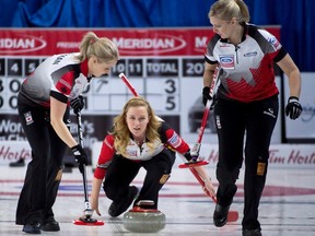 Team Canada skip Chelsea Carey (centre) watches her shot as lead Laine Peters (right) and second Jocelyn Peterman (left) sweep during the 6th draw against Russia at the World Women's Curling Championship in Swift Current, Sask., on Monday, March 21, 2016. (Jonathan Hayward/THE CANADIAN PRESS)