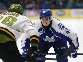 Mikkel Aagaard, right, of the Sudbury Wolves, and Mike Amadio, of North Bay Battalion, prepare for a face-off during OHL action at the Sudbury Community Arena in Sudbury, Ont. on Friday March 18, 2016.