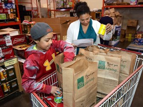 Bohdi Duncan, 11, and his mother Ani, both of London, help out at the London Food Bank of the first day of the Spring Food Drive on Thursday March 17, 2016. (London Free Press file photo)