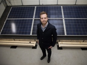 Iron + Earth Executive Director Liam Hildebrand poses for a photo in front of a solar array at Iron + Earth's office, in Edmonton Alta. on Monday March 21, 2016. Photo by David Bloom