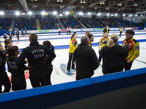 Referees speak to team South Korea as Team Japan looks on during the seventh draw at the women's world curling championships in Swift Current, Sask., on March 21, 2016. (THE CANADIAN PRESS/Jonathan Hayward)
