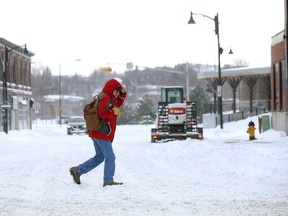 A pedestrian makes his way across Elgin Street in Sudbury, Ont. on Tuesday December 29, 2015. Environment Canada warns significant snowfall is possible by Thursday. Gino Donato/Sudbury Star/Postmedia Network