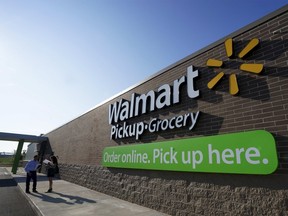 People talk outside a Walmart Pickup-Grocery test store in Bentonville, Arkansas, in this file photo taken June 4, 2015. REUTERS/Rick Wilking/Files
