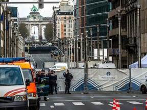 Policemen stand guard near a security perimeter set in the Rue de la Loi near the Maalbeek subway station, in Brussels, on March 22, 2016, after an explosion killed at least 11 people, according to spokesman of Brussels' fire brigade  A string of explosions rocked Brussels airport and a city metro station on Tuesday, killing at least 13 people, according to media reports, as Belgium raised its terror threat to the maximum level.