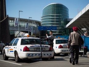 An RCMP officer patrolling the departures area at Vancouver International Airport in Richmond, B.C., on Tuesday March 22, 2016. Officials said security at the airport has been heightened after the attack on the Brussels airport in Belgium. (THE CANADIAN PRESS/Darryl Dyck)